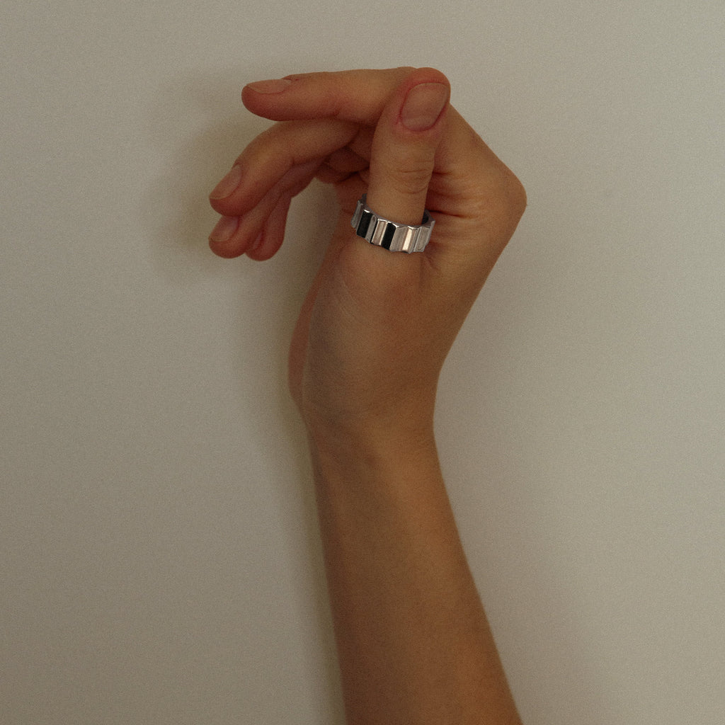 Hand with a ring on a plain background