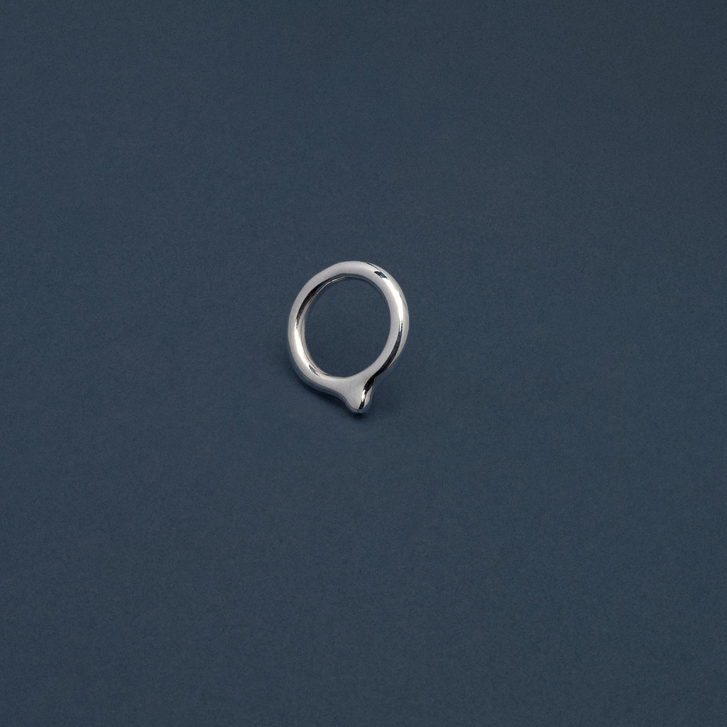 Silver earring on a dark blue background