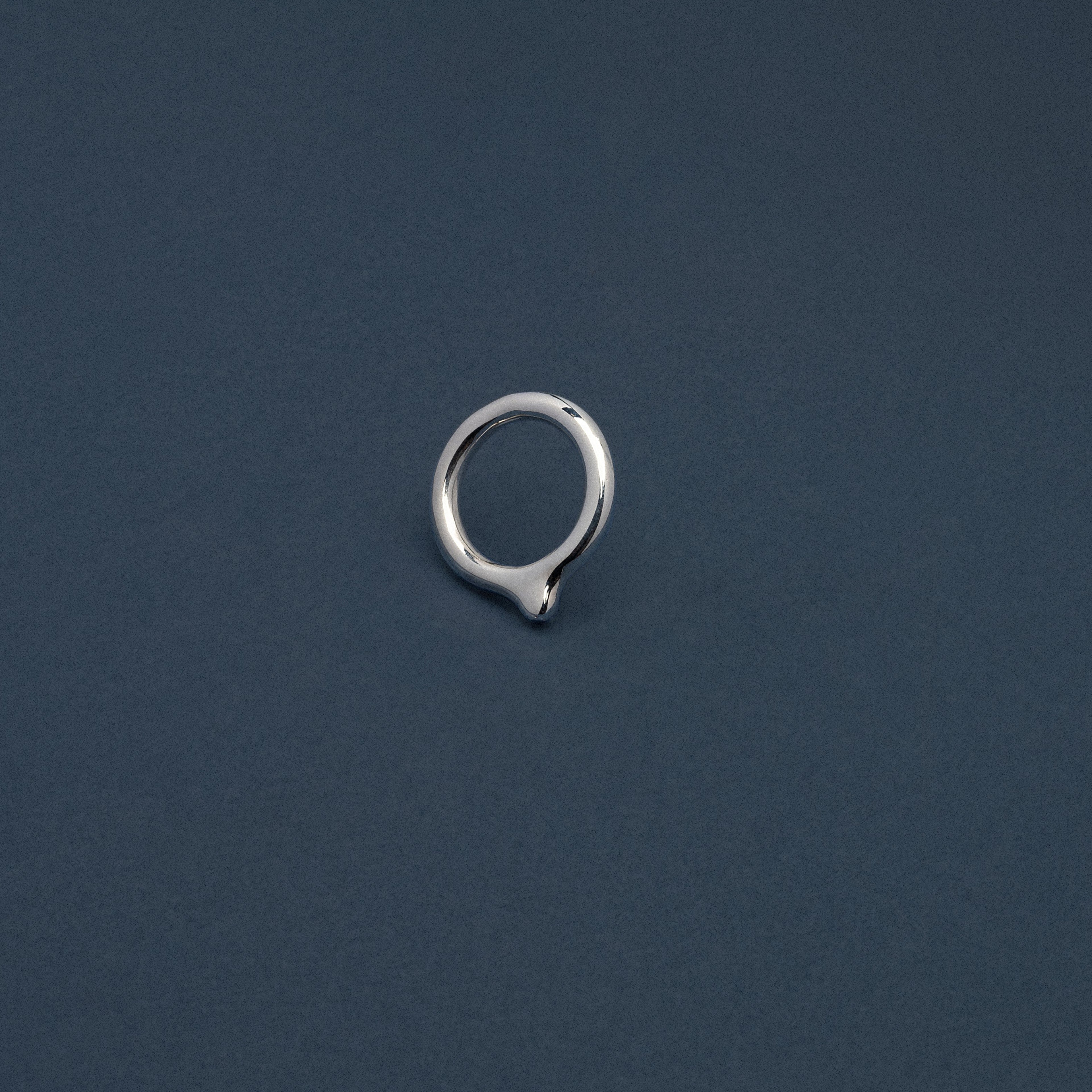 Silver earring on a dark blue background