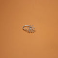 Silver ring with star-like design on an orange background