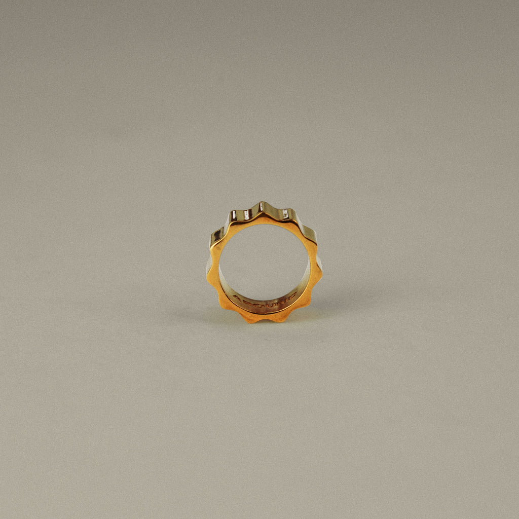 Gold ring with embedded stones on a beige background