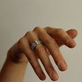 Hand with a ring on a plain background