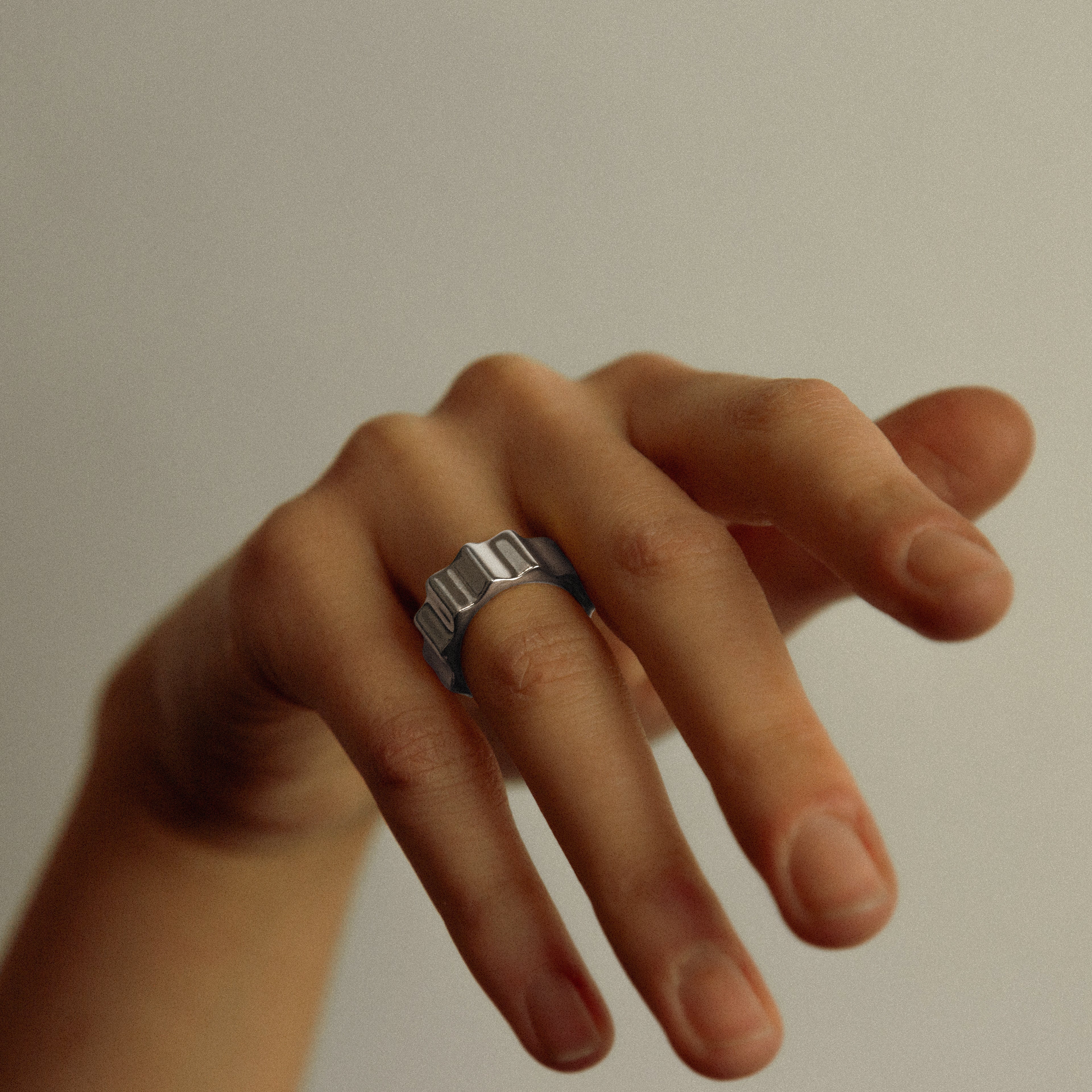Hand with a ring on a plain background