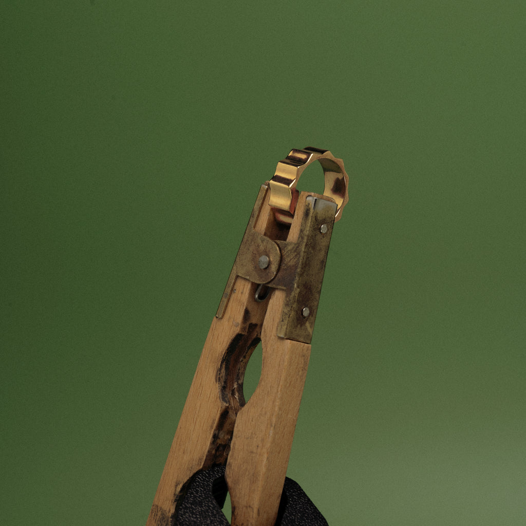 Vintage wooden and metal clothespin on a green background