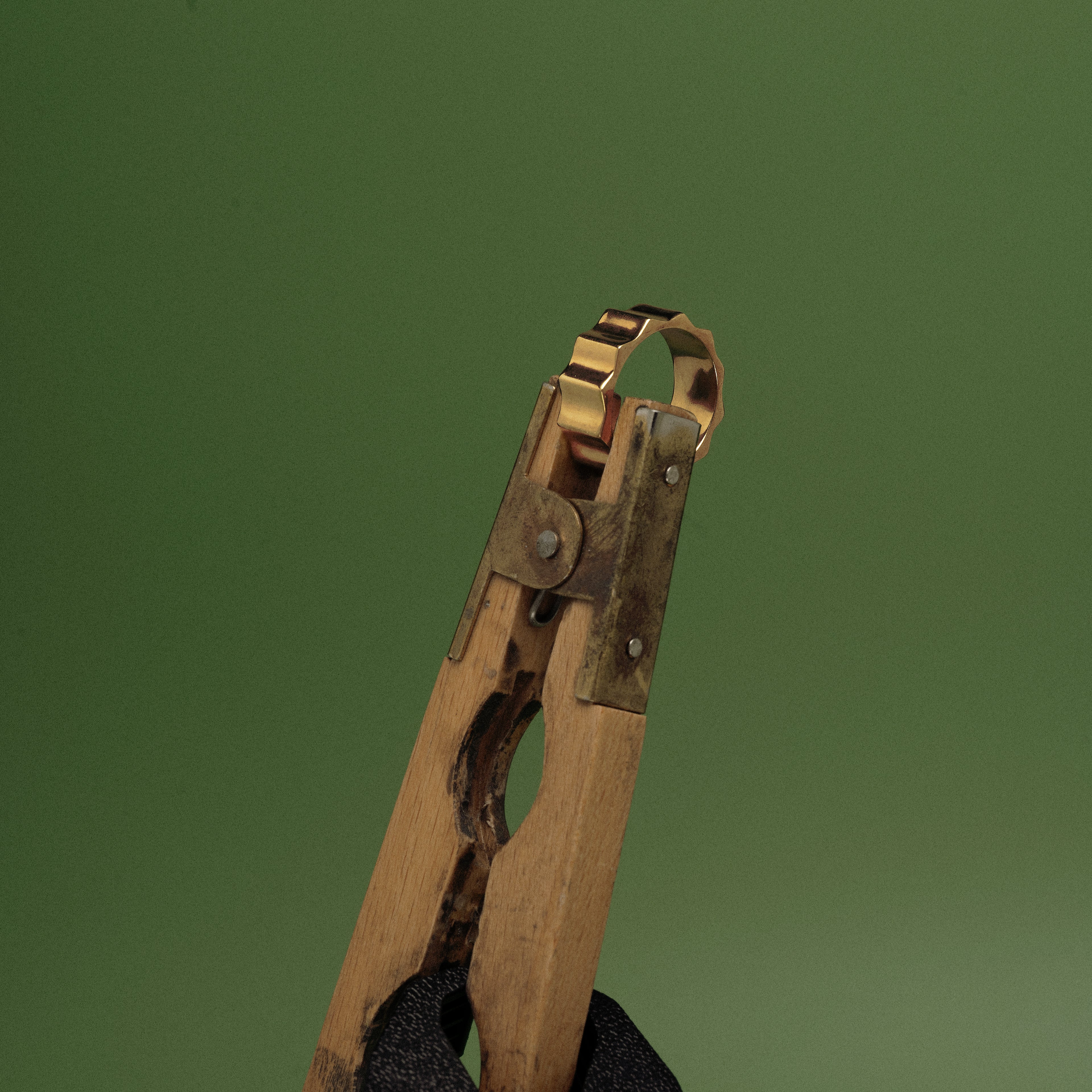 Vintage wooden and metal clothespin on a green background